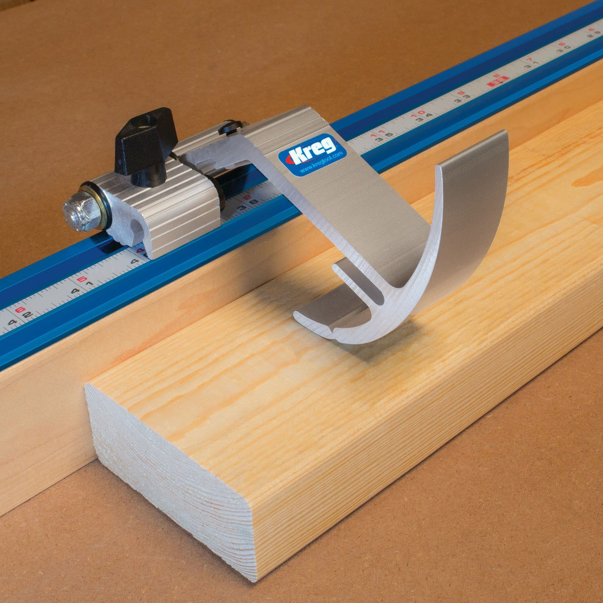 Kreg Tool KMS7801 Swing Stop set against wood stock on Kreg Top Trak for accurate repeat cuts on a woodworking station