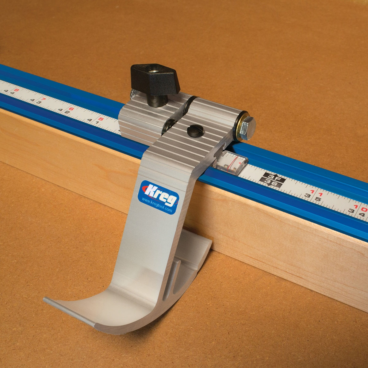 Kreg Tool KMS7801 Swing Stop installed on Kreg track for repeatable measuring on a woodworking fence with dimensional lumber in a shop setup