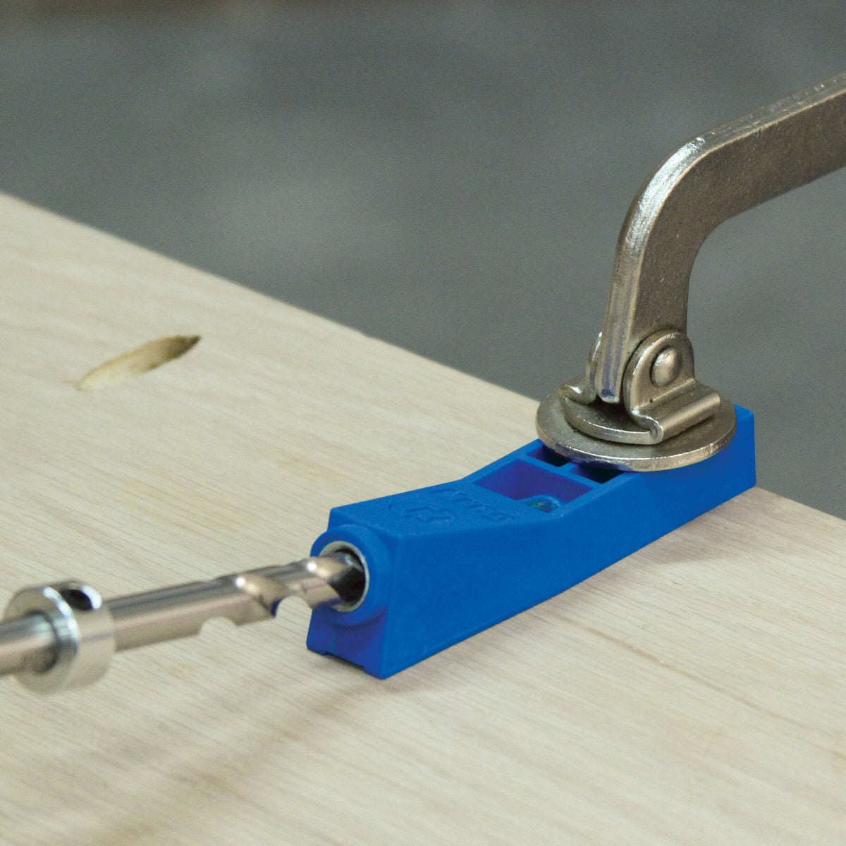 Kreg Tool MKJKIT Mini Jig Kit guiding a step drill bit into a wood panel for accurate pocket-hole drilling