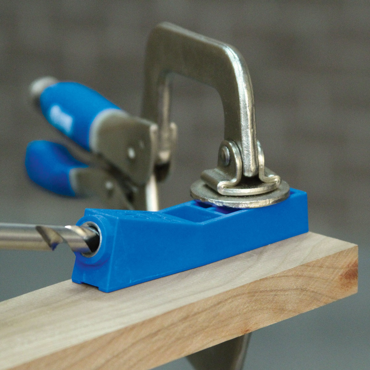 Kreg Tool MKJKIT Mini Jig Kit used on the edge of a wood board for compact pocket-hole joinery in a workshop setting
