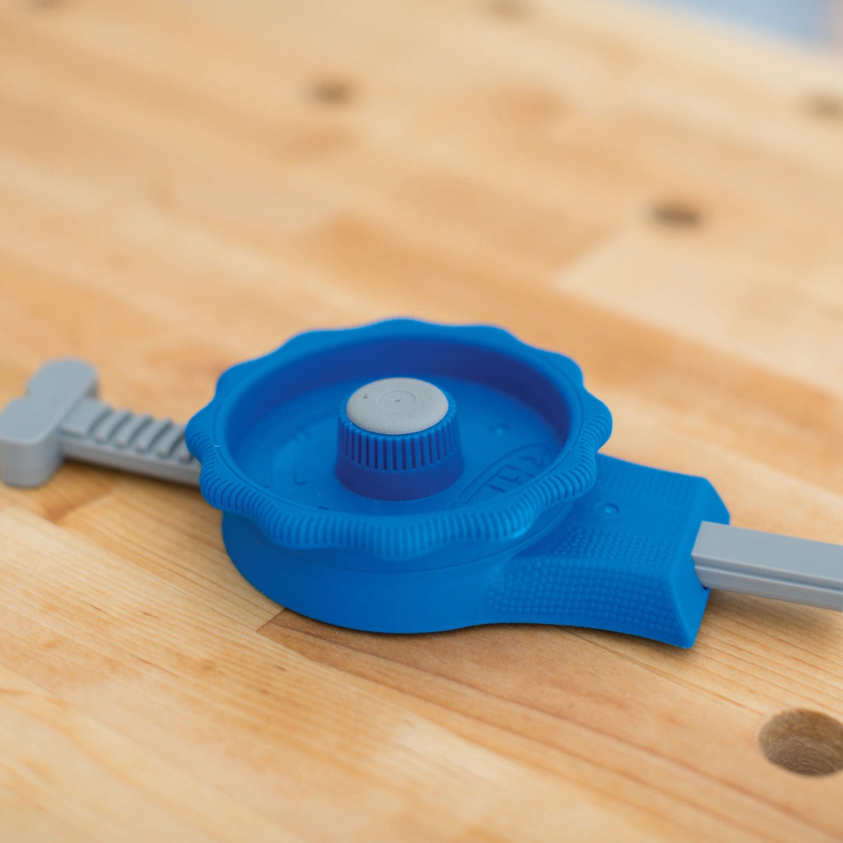 Kreg KBCIC In-Line Clamp on a woodworking bench showing the adjustment dial and clamp body for holding different stock sizes