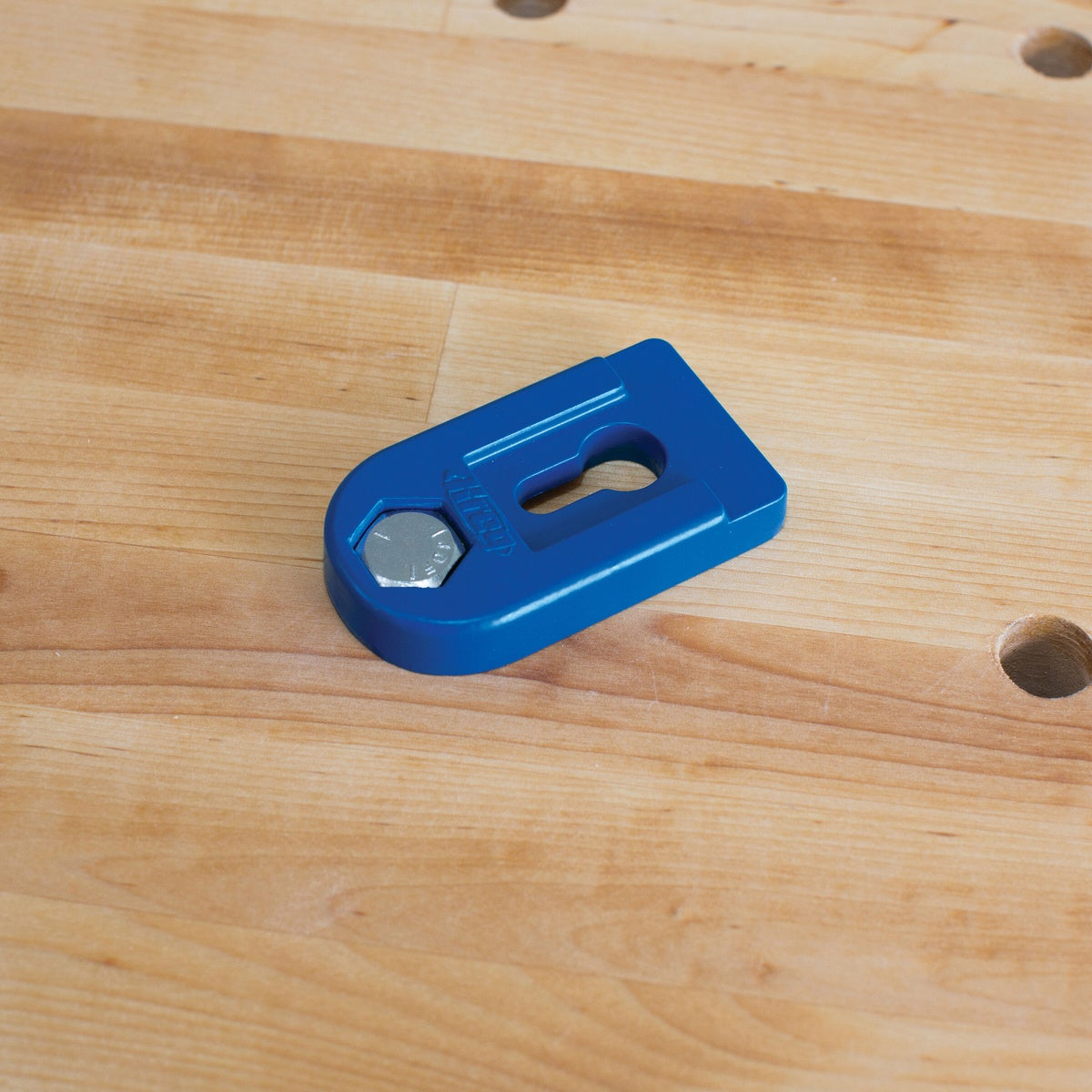 Kreg KBCBA Bench Clamp Base mounted in a woodworking bench top with bench dog holes for flexible clamp positioning