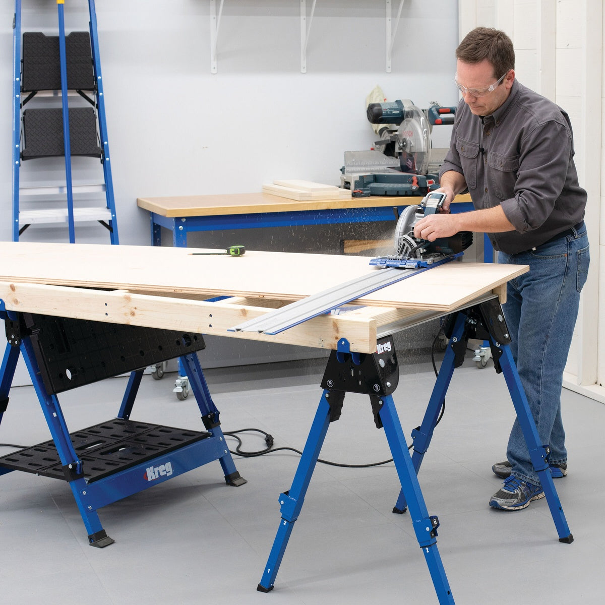 Kreg KWS500 Track Horse sawhorse supporting sheet material during circular saw cutting in a workshop setup