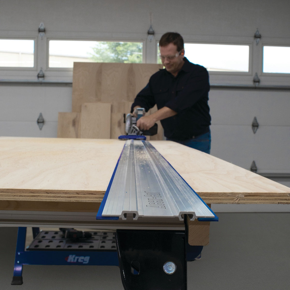 Kreg KMA2750 Accu-Cut Expansion Pack aluminum saw track positioned on a plywood work surface for long guided cuts