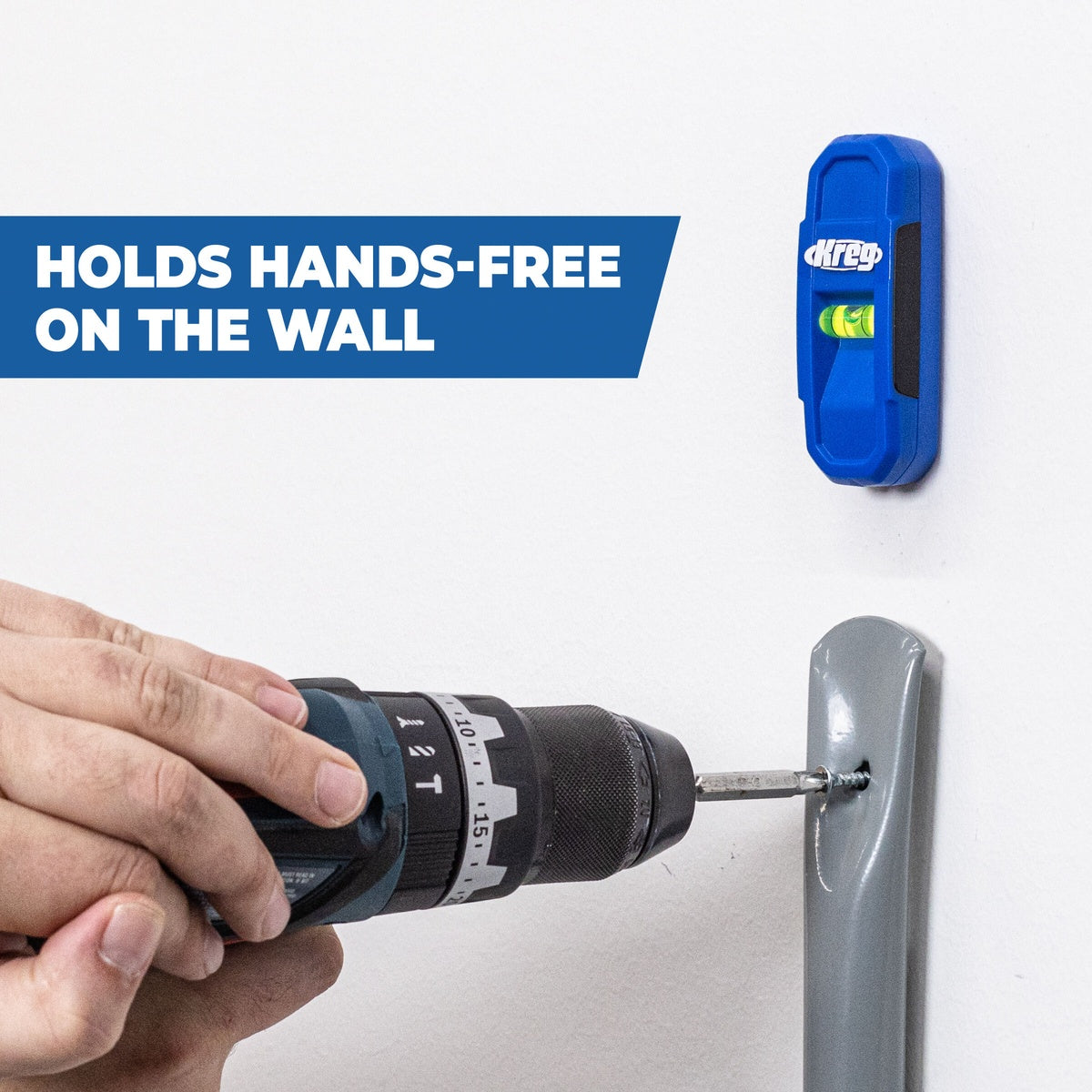 Kreg Tool KMM1000 Magnetic Stud Finder attached to a wall while a drill drives a fastener during shelf or hardware installation