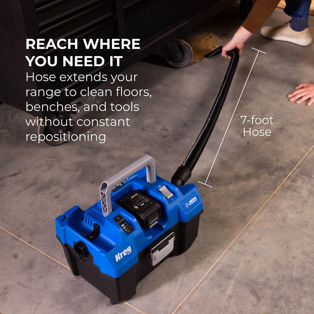cordless Kreg wet dry vacuum cleaning a concrete shop floor with long hose for bench and floor cleanup