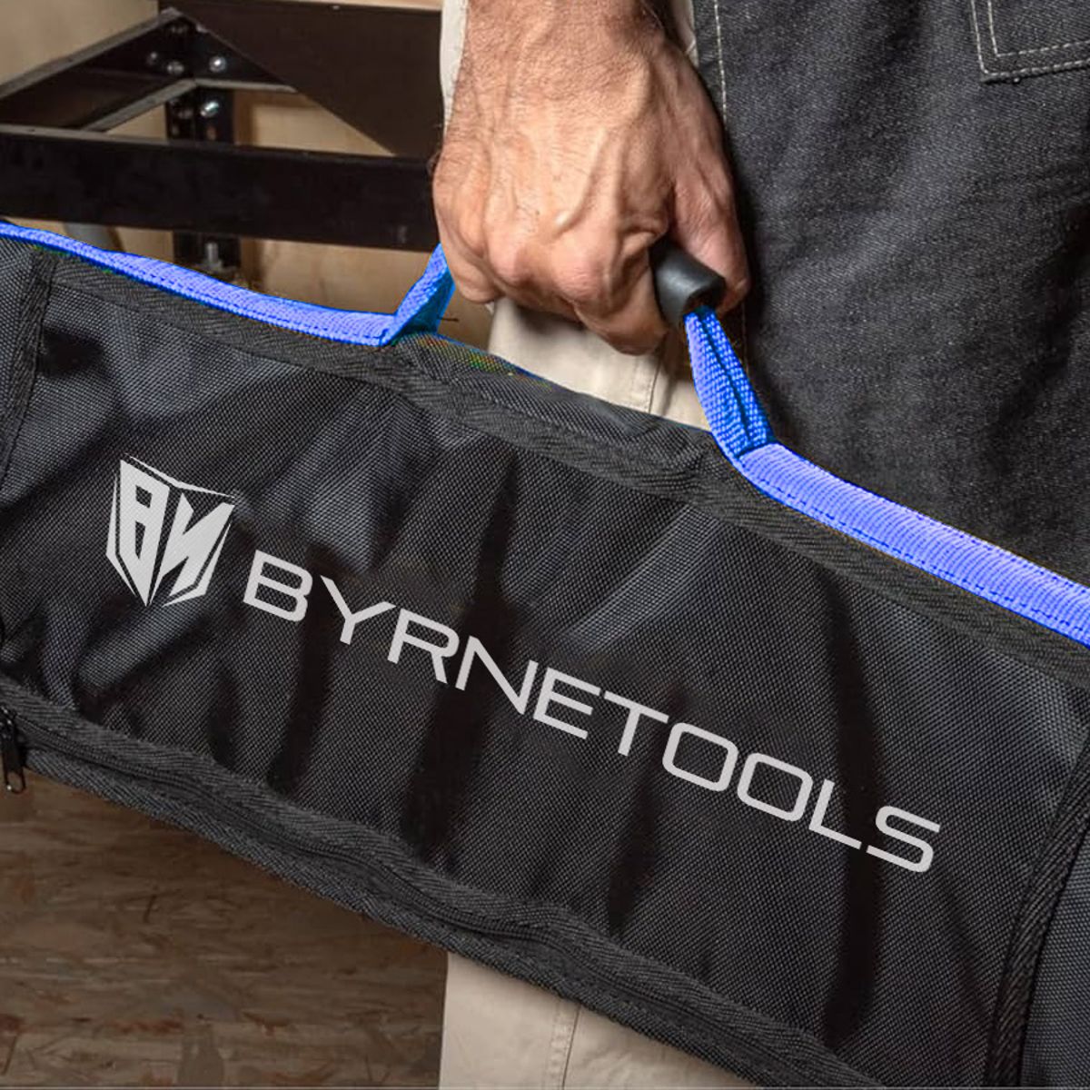 Contractor carrying the Byrne Guide Rail Bag 1400mm by its cloth handles on a jobsite