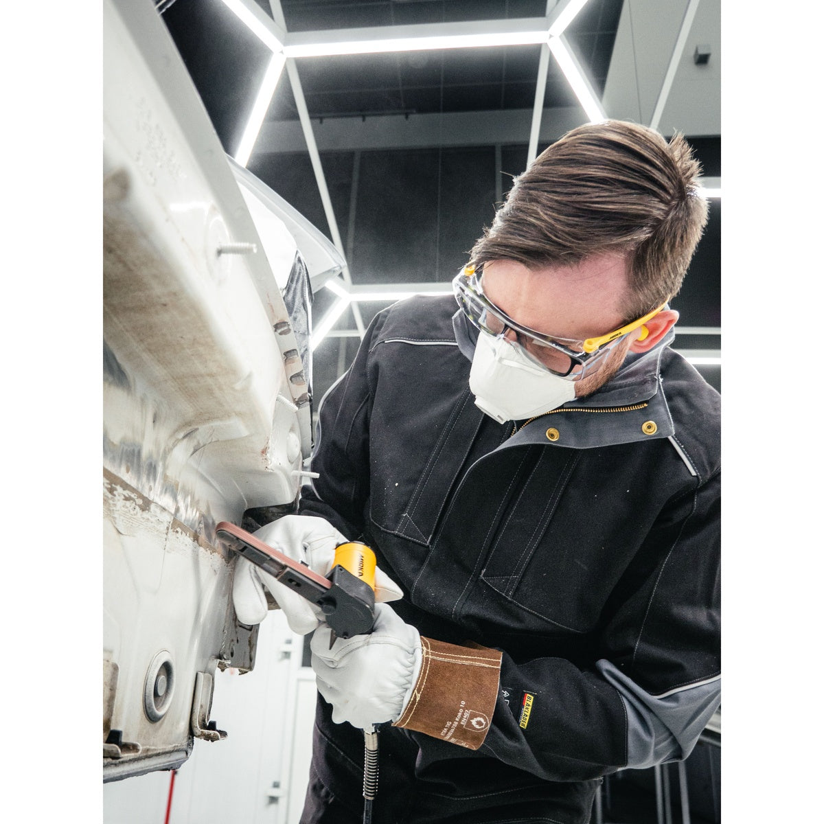 Mirka pneumatic belt sander being used on an automotive body panel