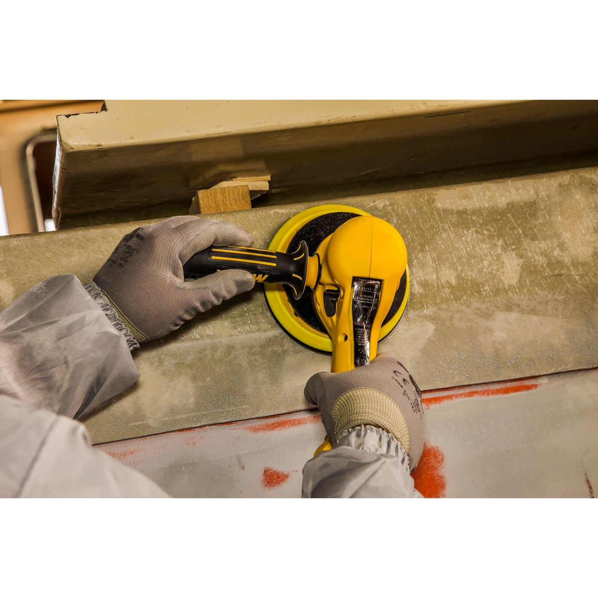 Mirka two-handed vacuum-ready random orbit sander in use on a panel surface