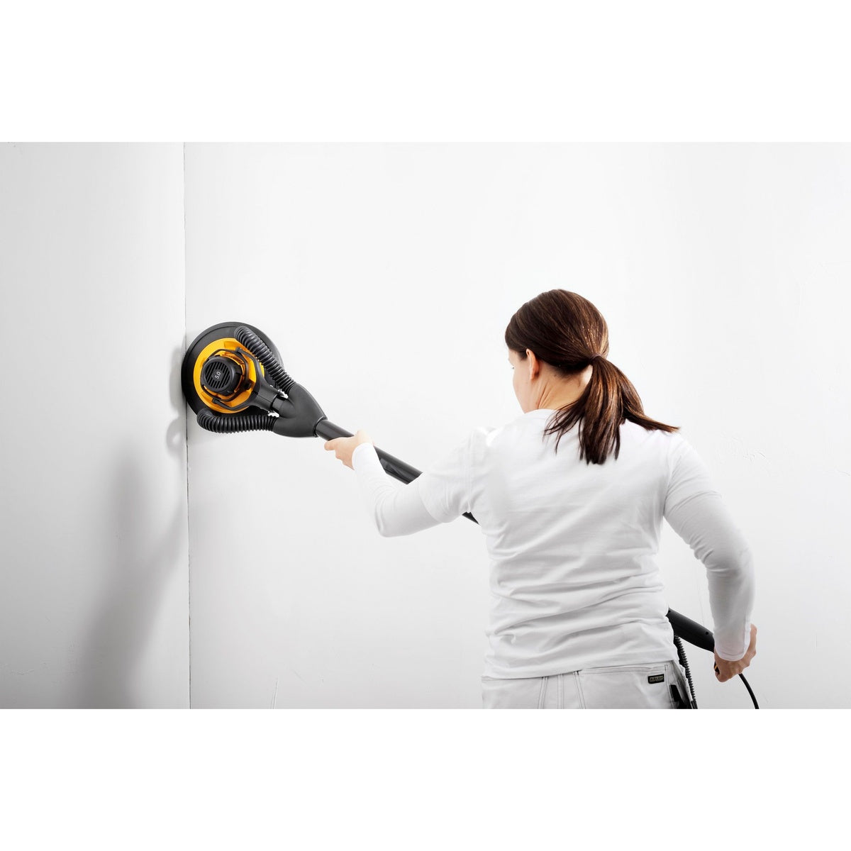 Mirka LEROS wall sander in use on an interior wall