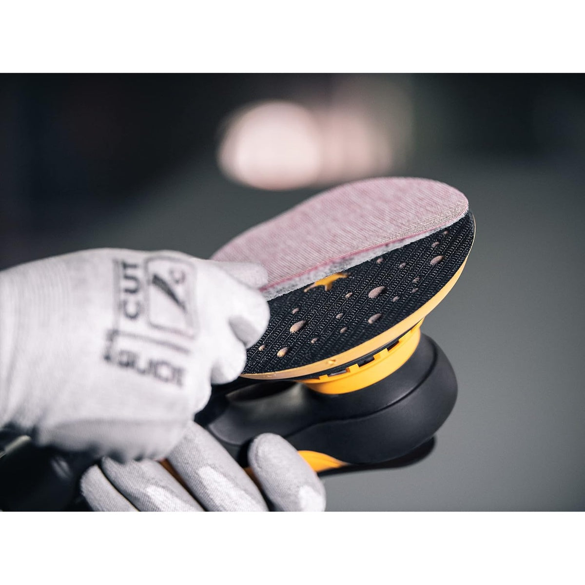 Applying a sanding disc to the Mirka DEROS backing pad