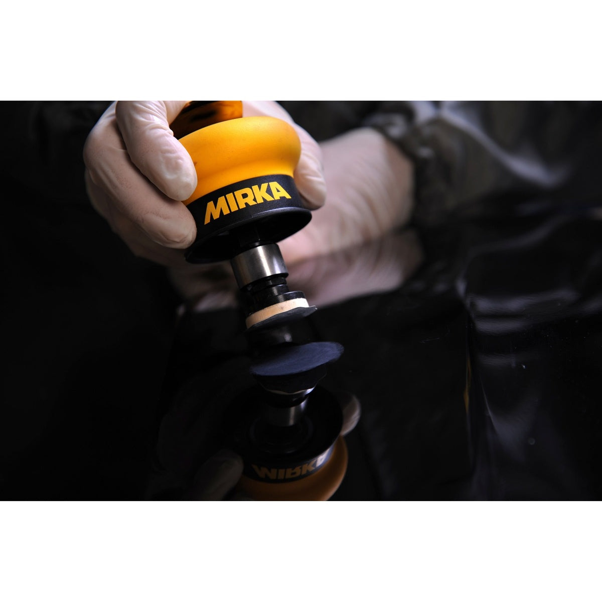 Mirka MROS mini orbital finish sander in use on a glossy surface