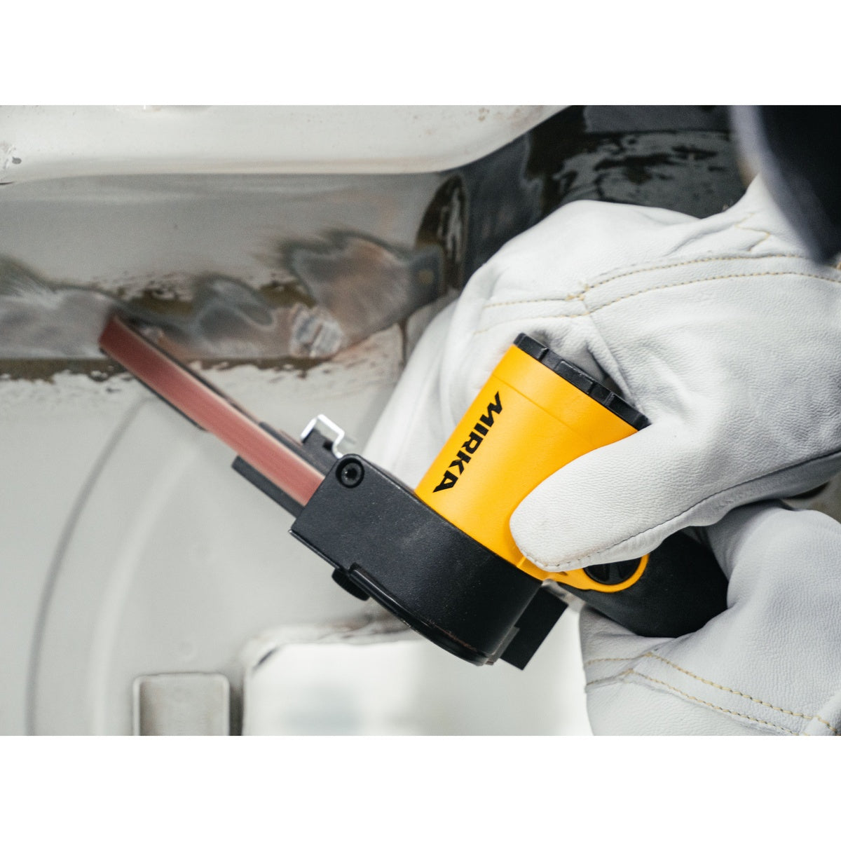 Mirka pneumatic belt sander sanding a metal weld joint