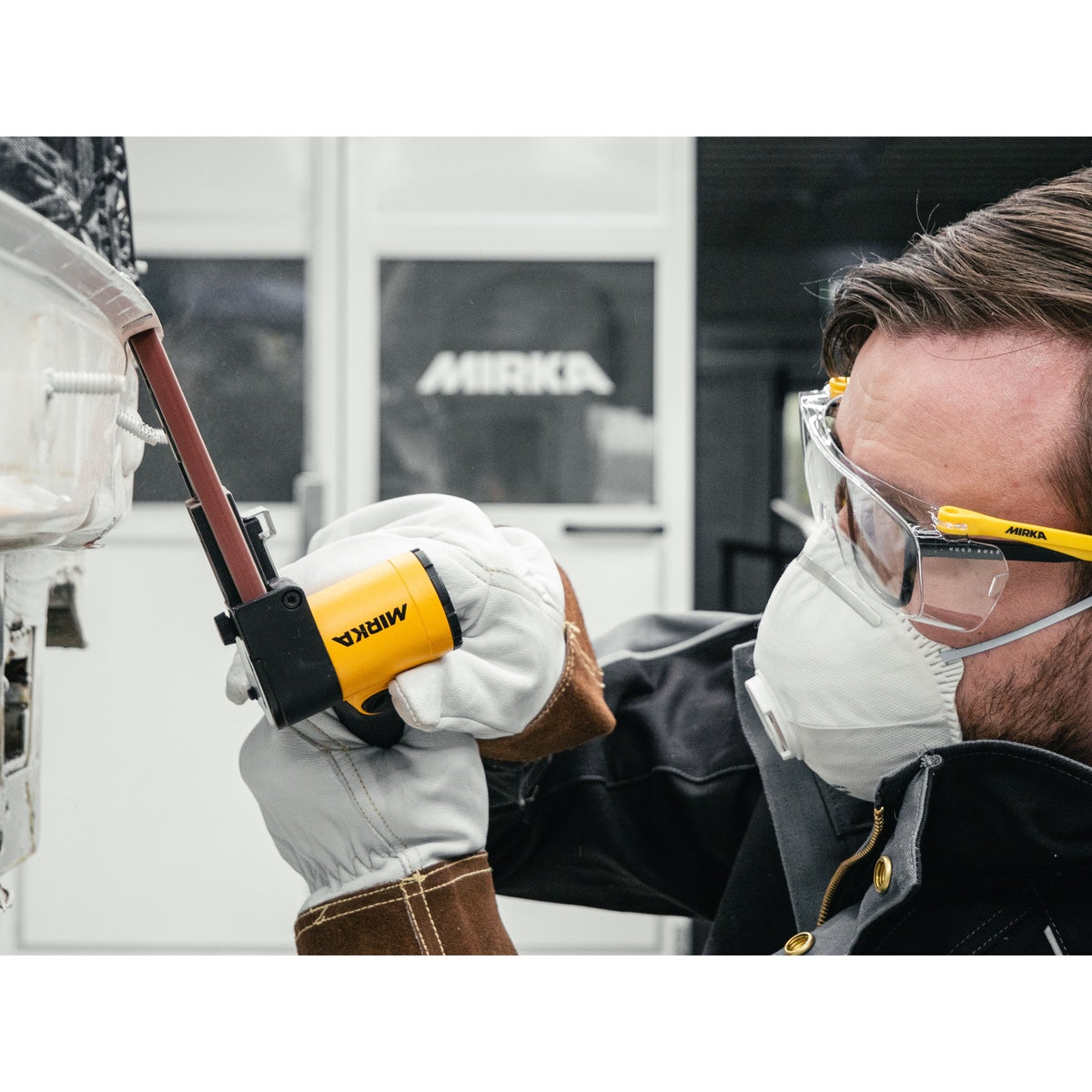 Mirka belt sander in use for spot weld removal on automotive panel
