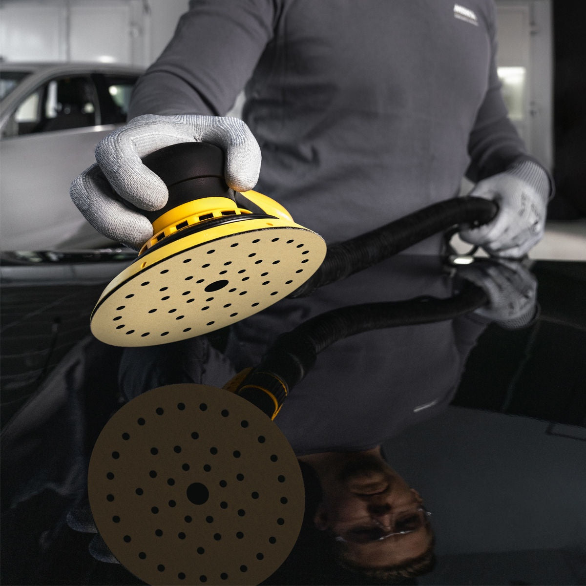 Mirka Gold Multifit 150 mm sanding disc mounted on a random orbit sander during automotive sanding