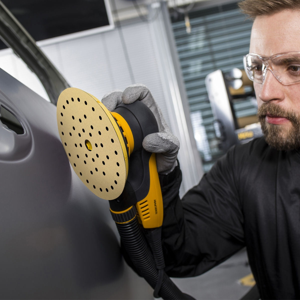 Mirka Gold Multifit sanding disc attached to a Mirka sander on a vehicle panel