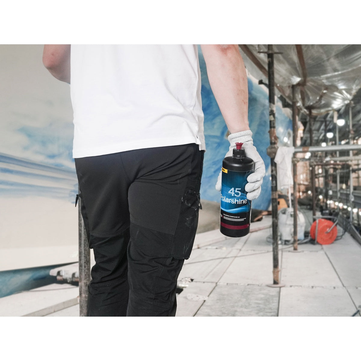 Person holding Mirka Polarshine 45 polishing compound bottle at a worksite