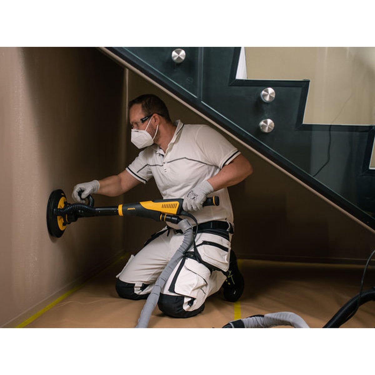 Mirka LEROS wall sander in use with sanding disc on interior wall