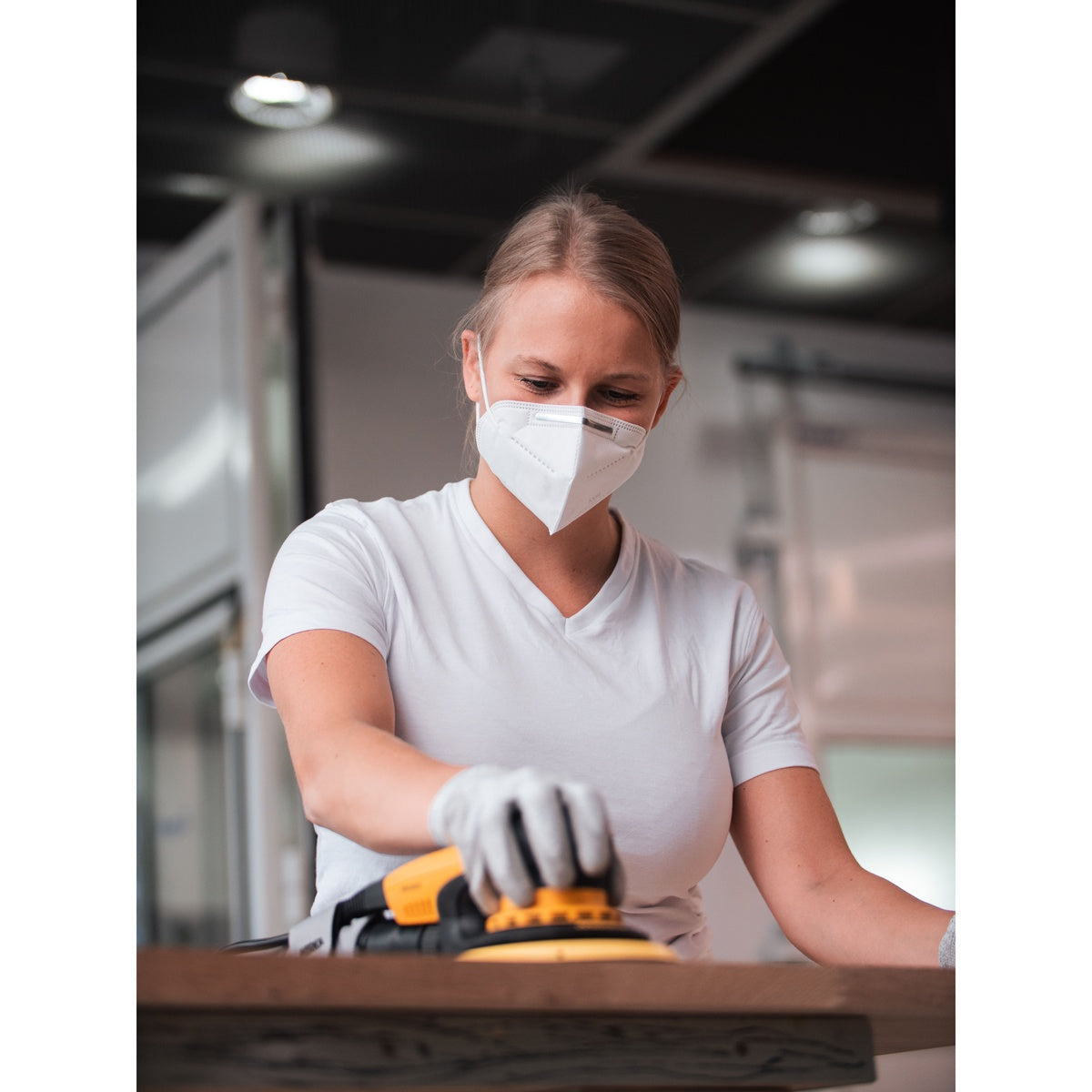 Orbital sander using a Mirka Abranet net sanding disc on a wood surface