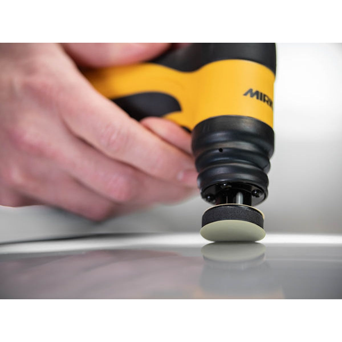Mirka Iridium SR abrasive disc mounted on a Mirka spot repair sander during finishing
