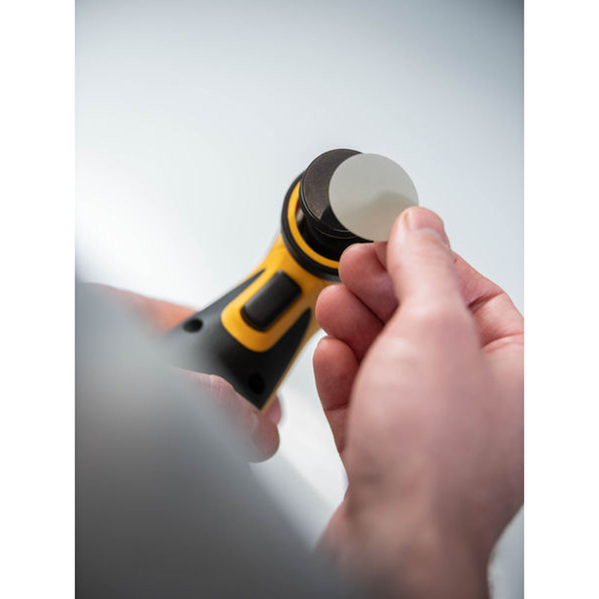 Applying a Mirka Iridium SR PSA abrasive disc to a spot repair sanding pad