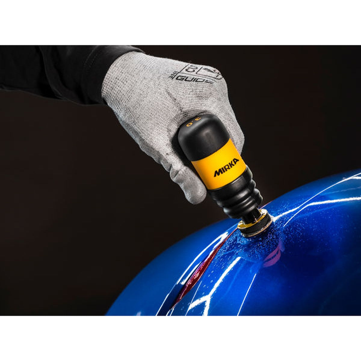 Mirka Iridium SR PSA abrasive disc polishing automotive paint on a blue panel