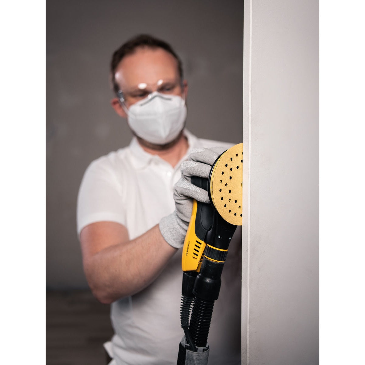 Mirka orbital sander fitted with a Gold Multifit sanding disc for wall sanding