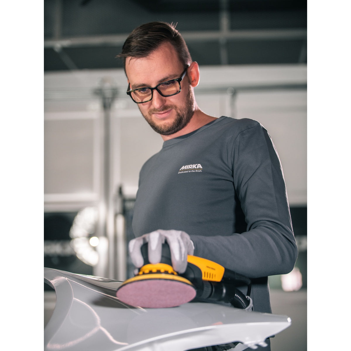 Mirka Abranet Ace HD sanding disc attached to an orbital sander during automotive sanding