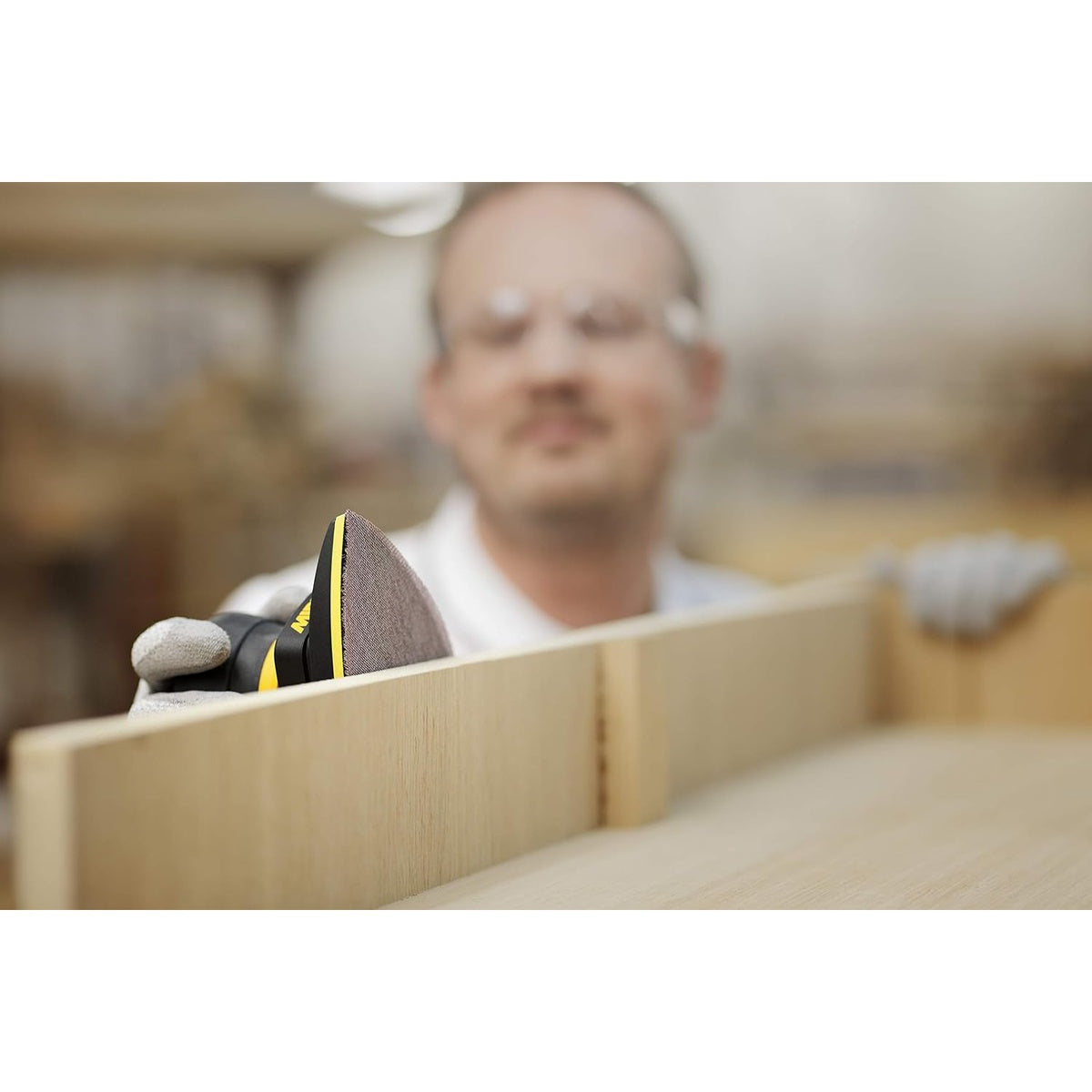 Mirka detail sander using Abranet triangular sanding sheet on a wood panel edge