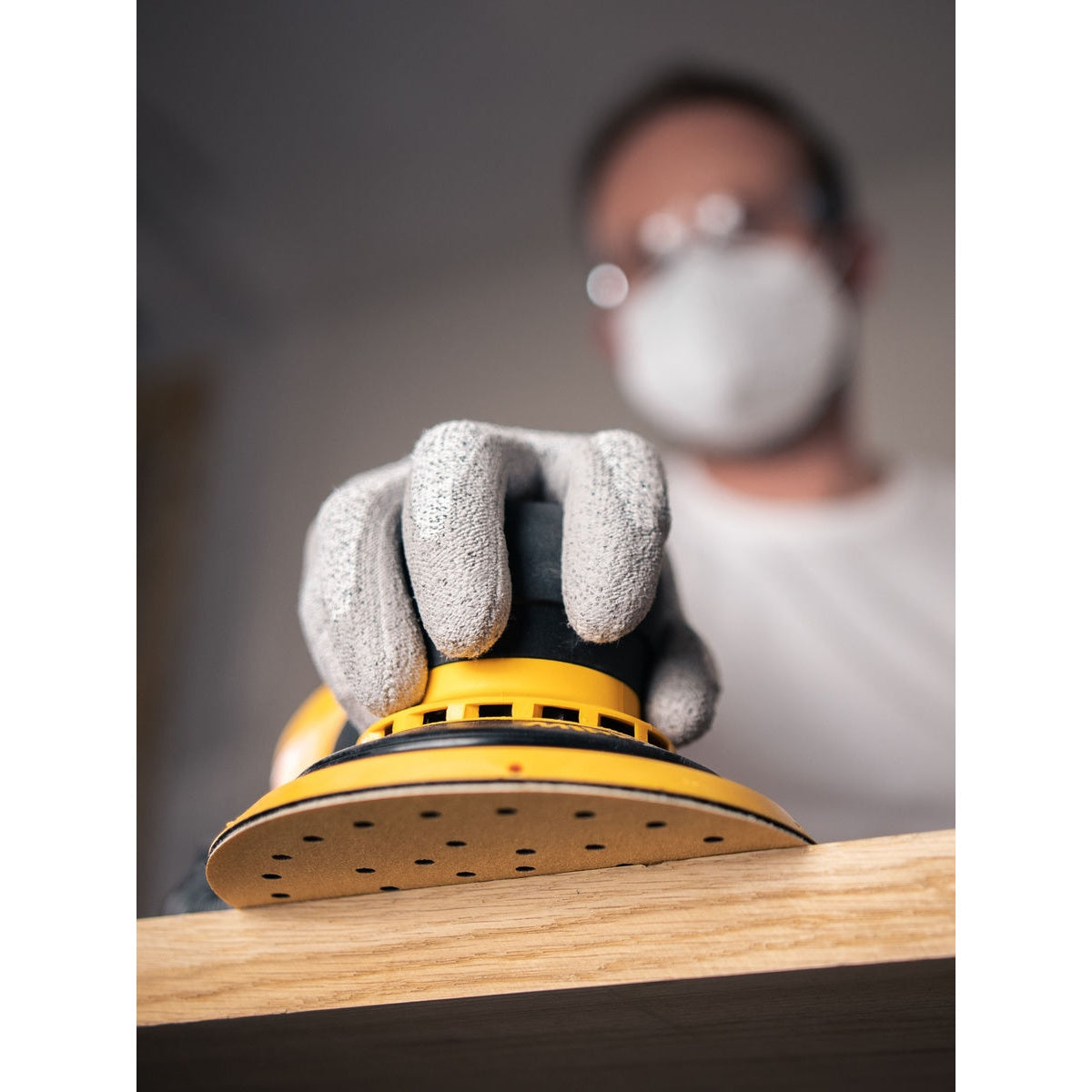 Close-up of Mirka Gold Multifit sanding disc sanding a wood surface