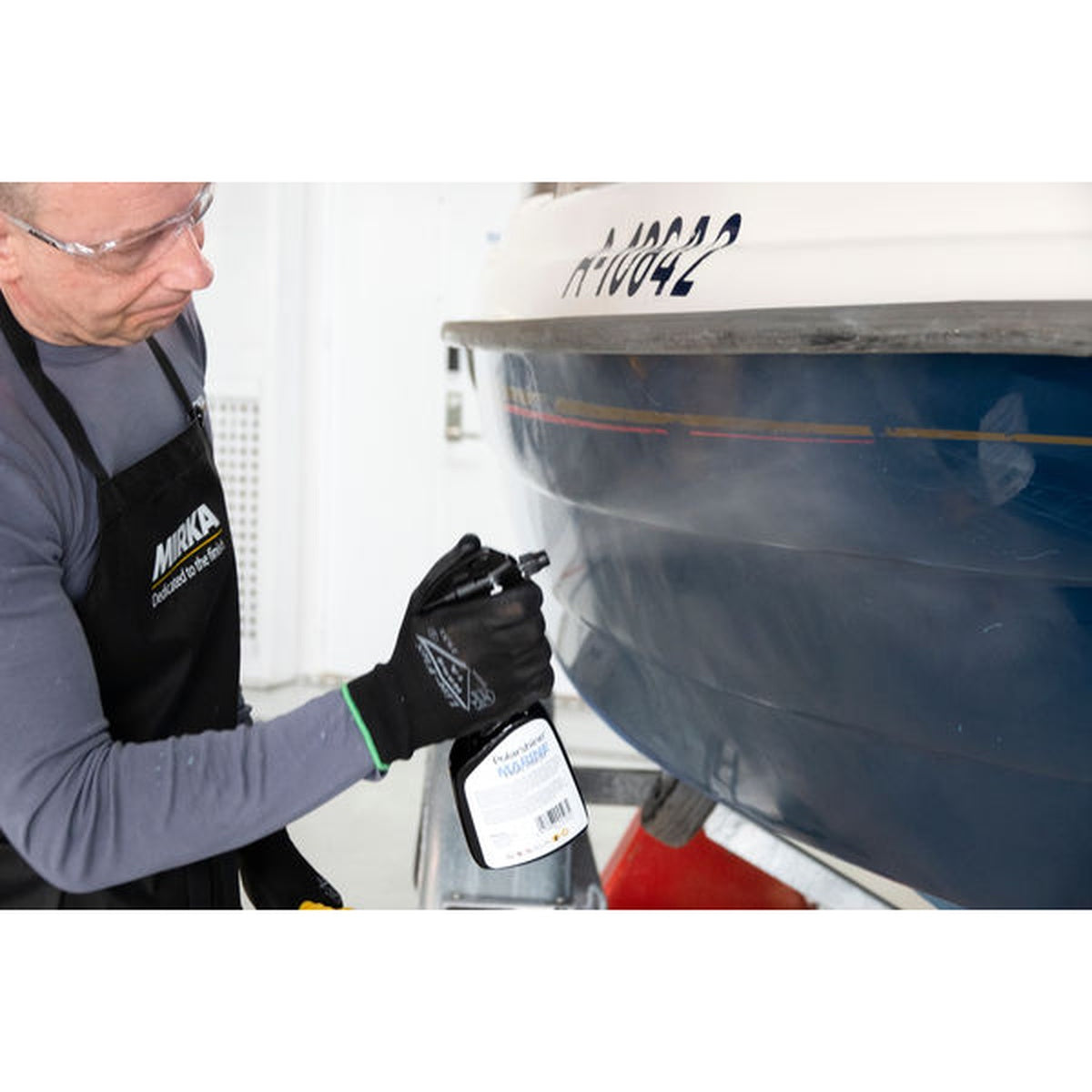 Person applying Mirka Polarshine Marine Final Finish spray to a boat hull