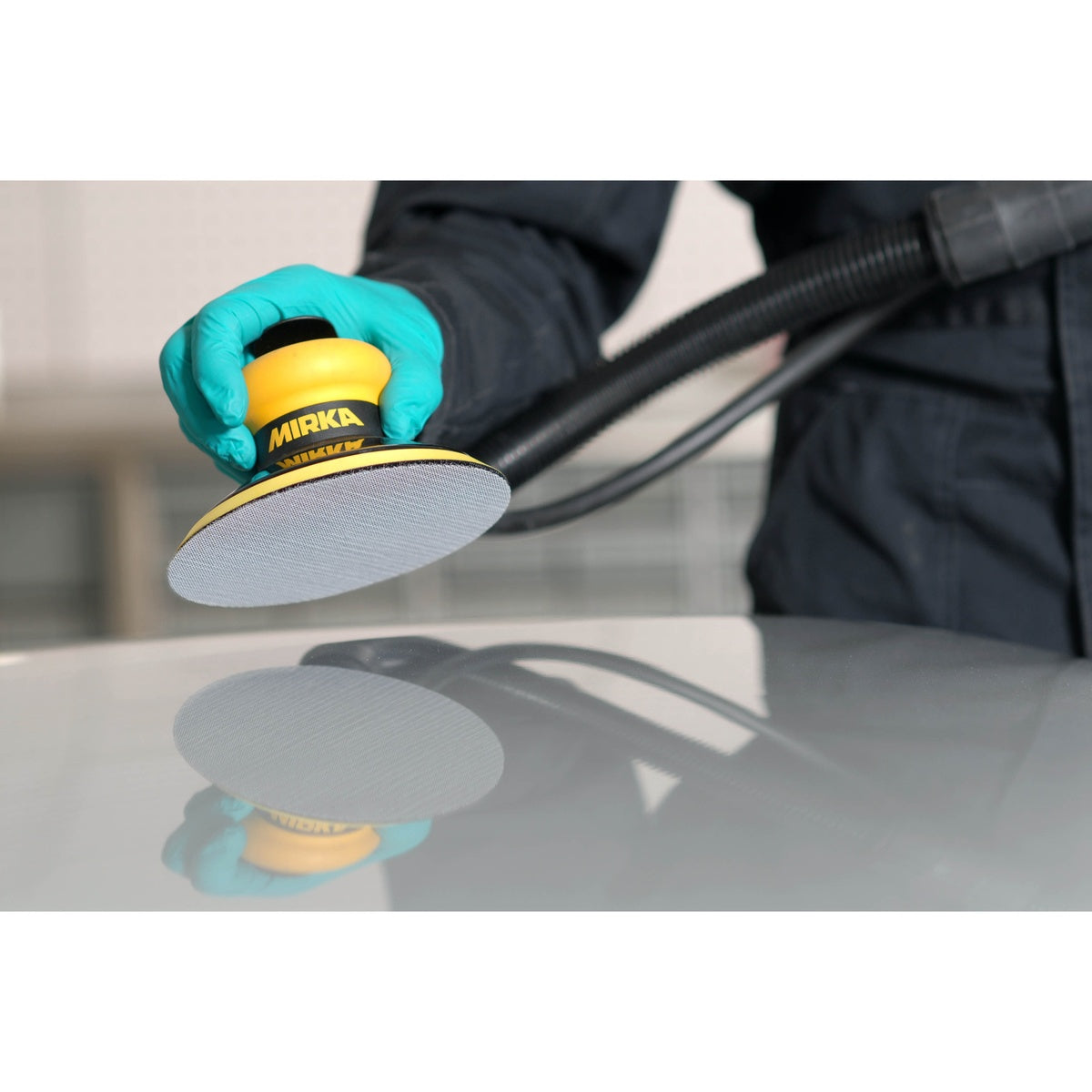 Mirka Autonet sanding disc attached to a Mirka orbital sander during surface sanding
