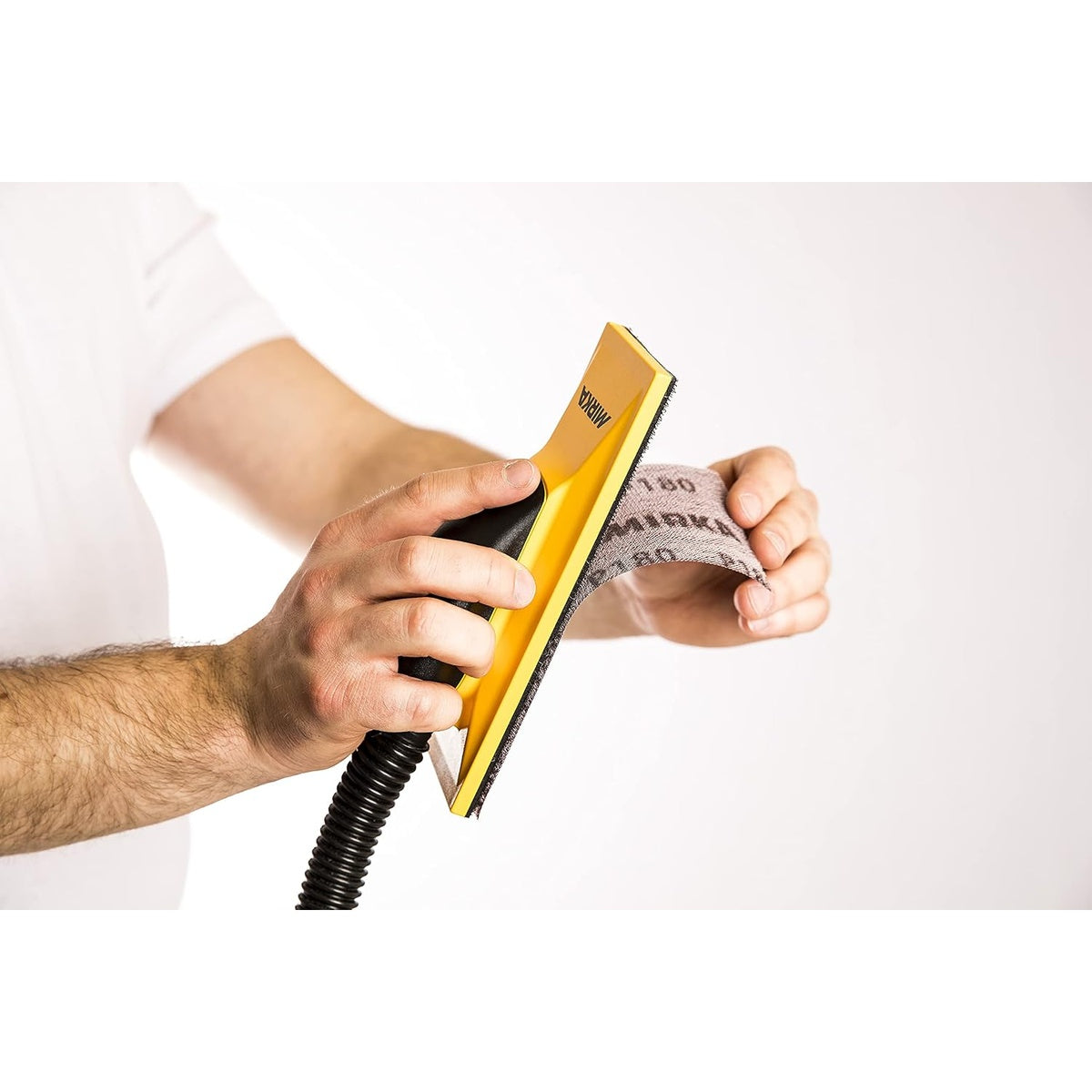 Mirka Abranet net sanding sheet used on a hand sanding block with vacuum hose