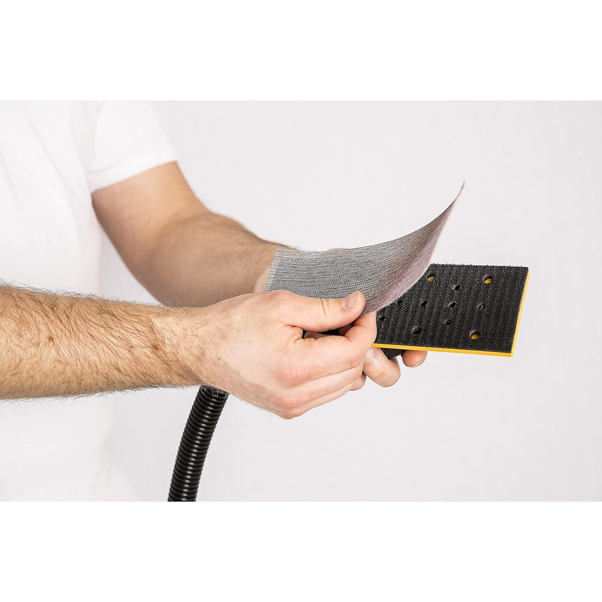 Mirka Abranet hook and loop sanding sheet being attached to a sanding block pad