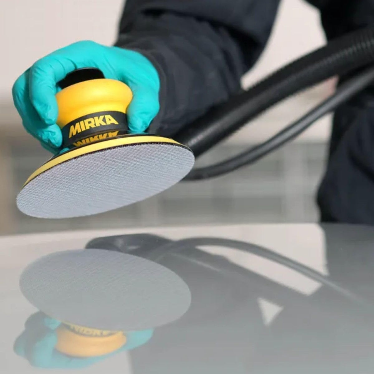 Mirka orbital sander using a mesh sanding disc on a smooth surface