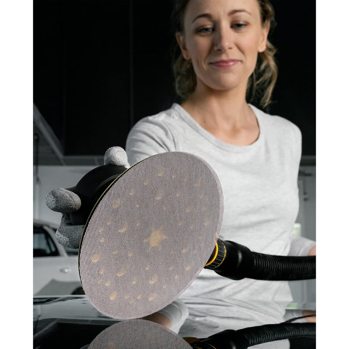 Mirka Abranet 6-inch mesh sanding disc in use with vacuum-assisted sander