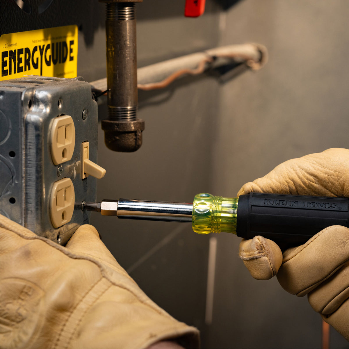 Klein Tools 11-in-1 multi-bit screwdriver from the 32500SDKIT set driving a screw on an electrical installation