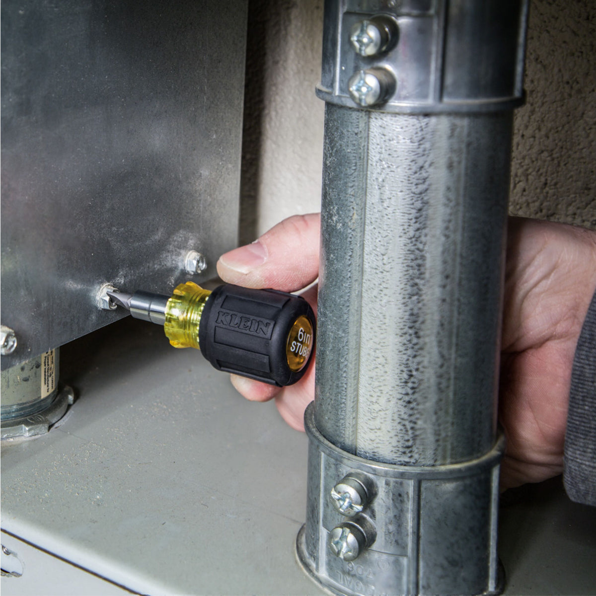 Klein Tools stubby multi-bit screwdriver from the 32500SDKIT set working in a tight space