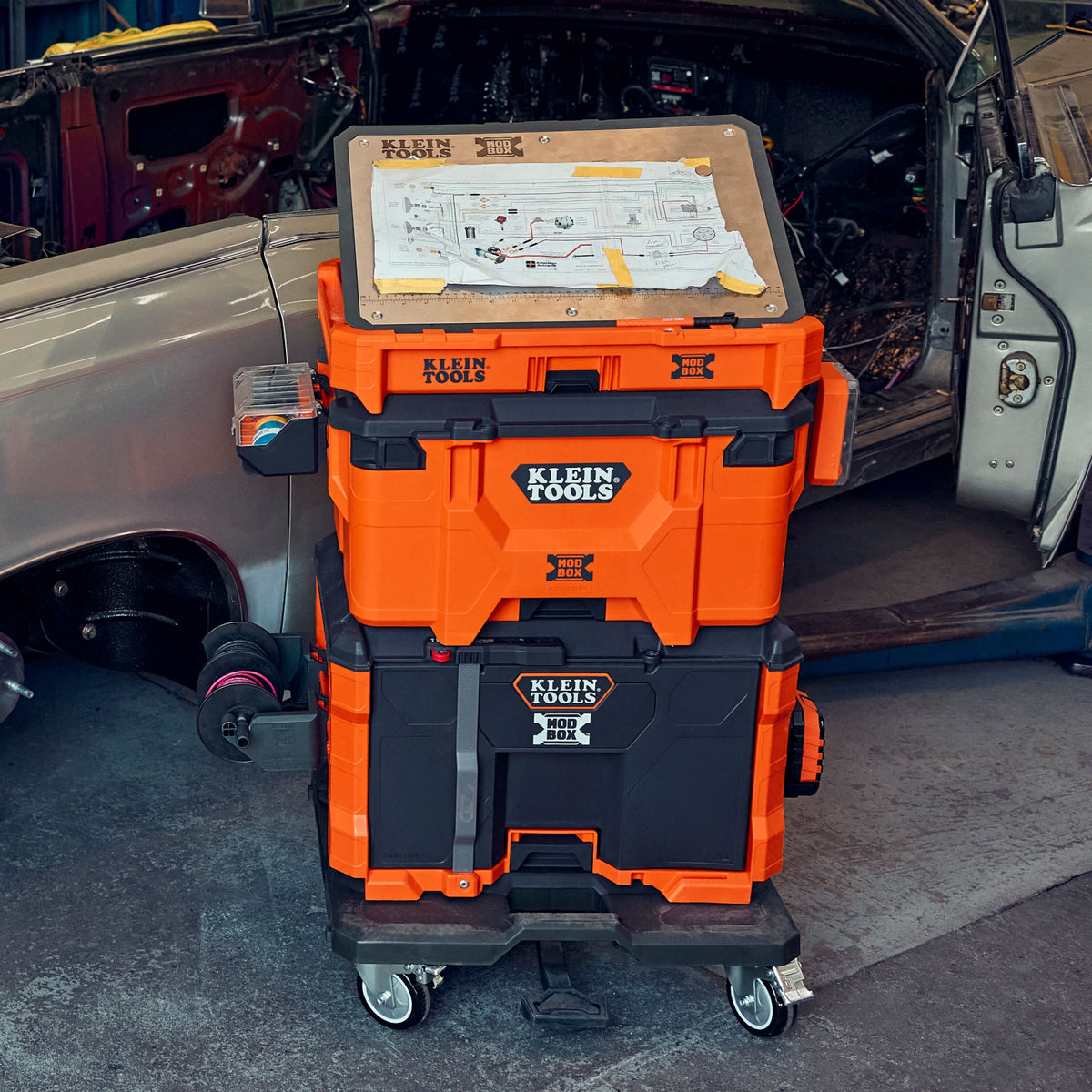 Klein Tools 54828MB MODbox caster dolly moving a MODbox stack across a jobsite